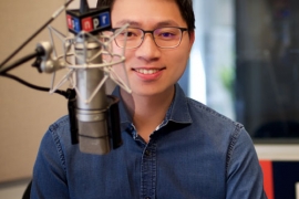 portrait of Hansi Lo Wang ’09 in front of a radio microphone